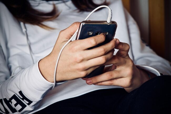 Woman_holding_cell_phone_3236059