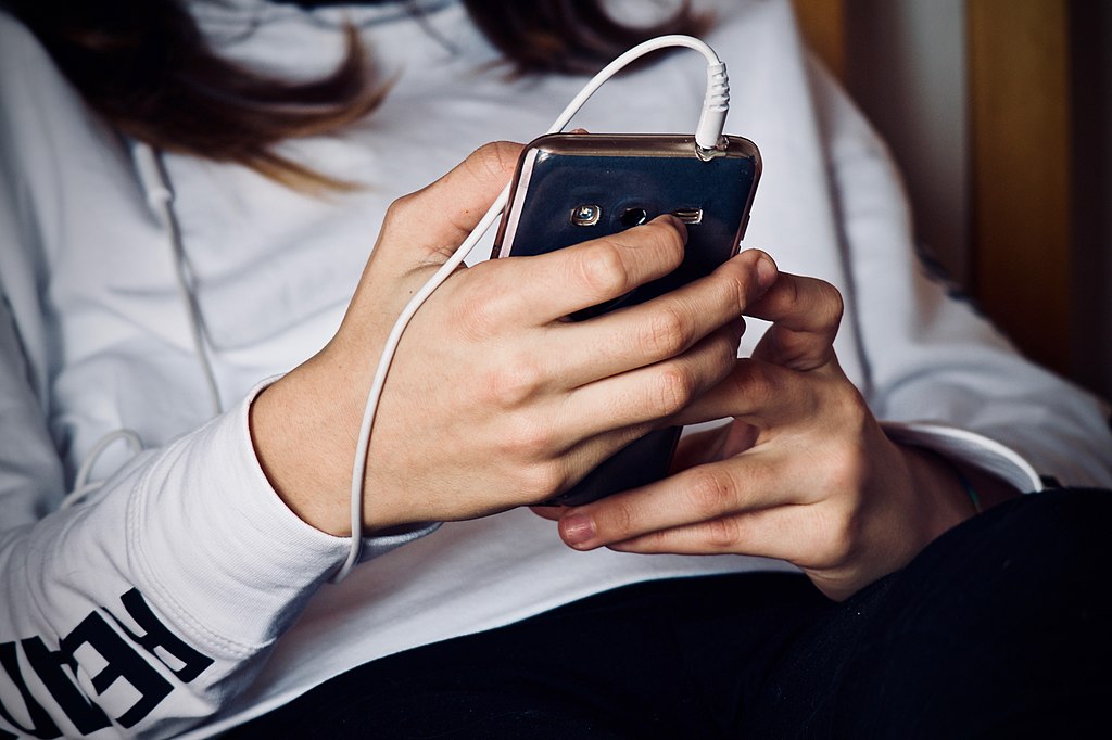 Woman_holding_cell_phone_3236059